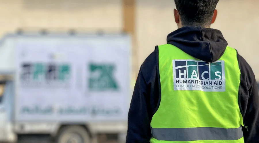 HACS Logo on the back of Staff member preparing to distribute aid to Gazan Refugees in Egypt.